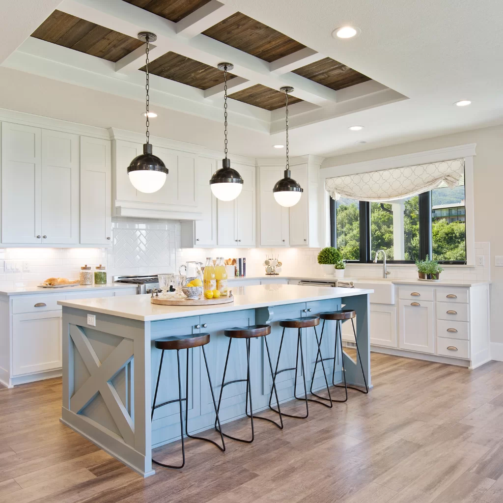 Farmhouse kitchen with blue island, pendant lights, and exposed wood beams