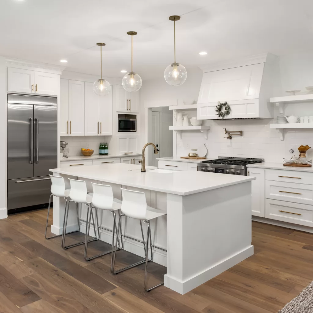 Modern white kitchen with large central island and wood flooring