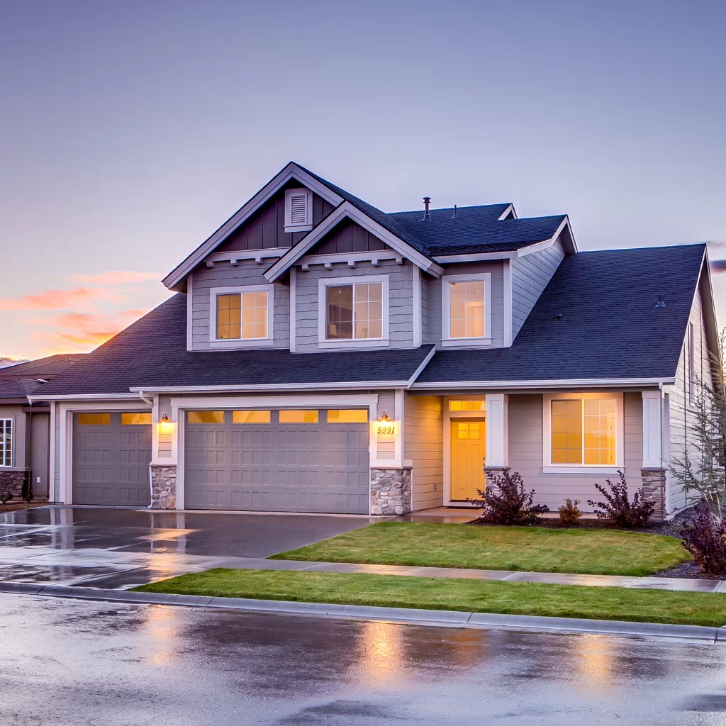 Modern two-story home with pitched asphalt roof and exterior lighting