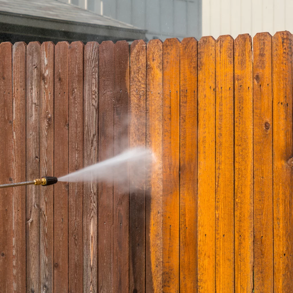 Power washing wooden fence for deep cleaning before refinishing
