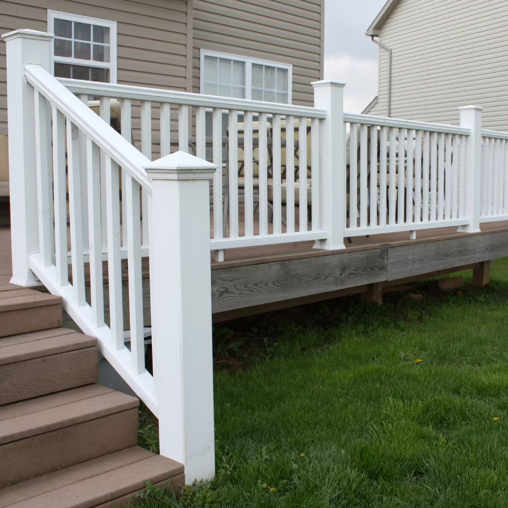 Traditional wooden deck with white railings and raised entry steps