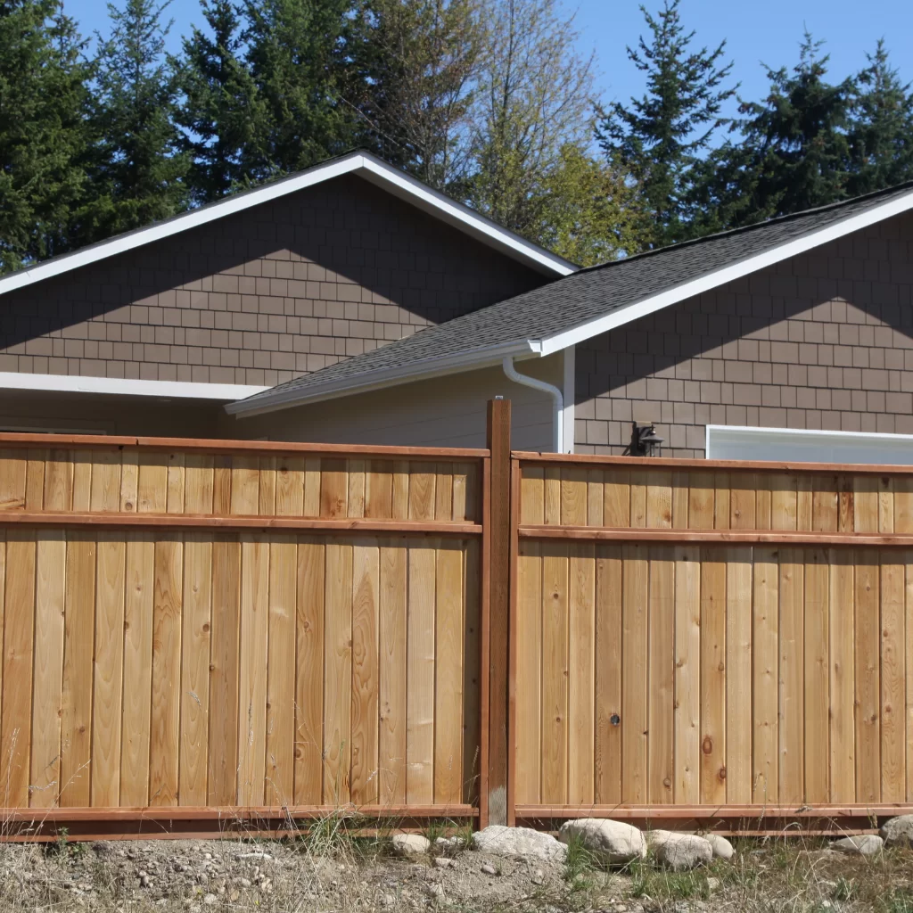 Modern vertical plank fence with dark frame and accent panels